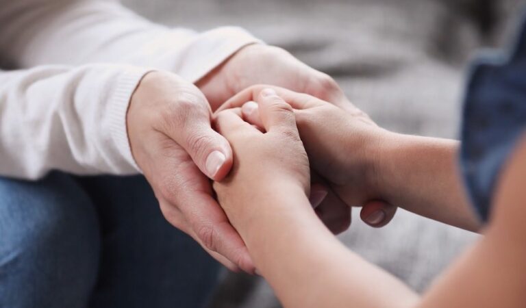 Foster parent and child holding hands together