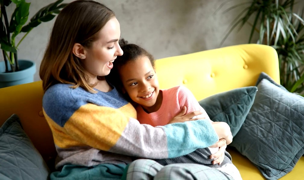 Foster parent with a girl on sofa